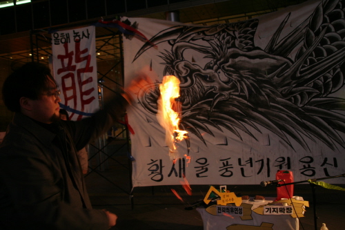 평택범대위와 황새울 긴급행동은 8일 광화문 동화면세점 앞에서 ‘황새울 풍년기원 용신제’를 열었다. 김덕진 사무국장이 용신에 올린 제문을 불태우고 있다. 